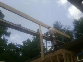 Carpenter setting a ridge beam over a new addition frame — Ice Dam Removal by Roofing Brothers in Valleyford