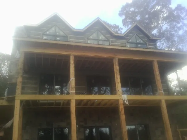 Dormers and porch framing on a large log home under construction — Roof Coating work by our crew in Valleyford